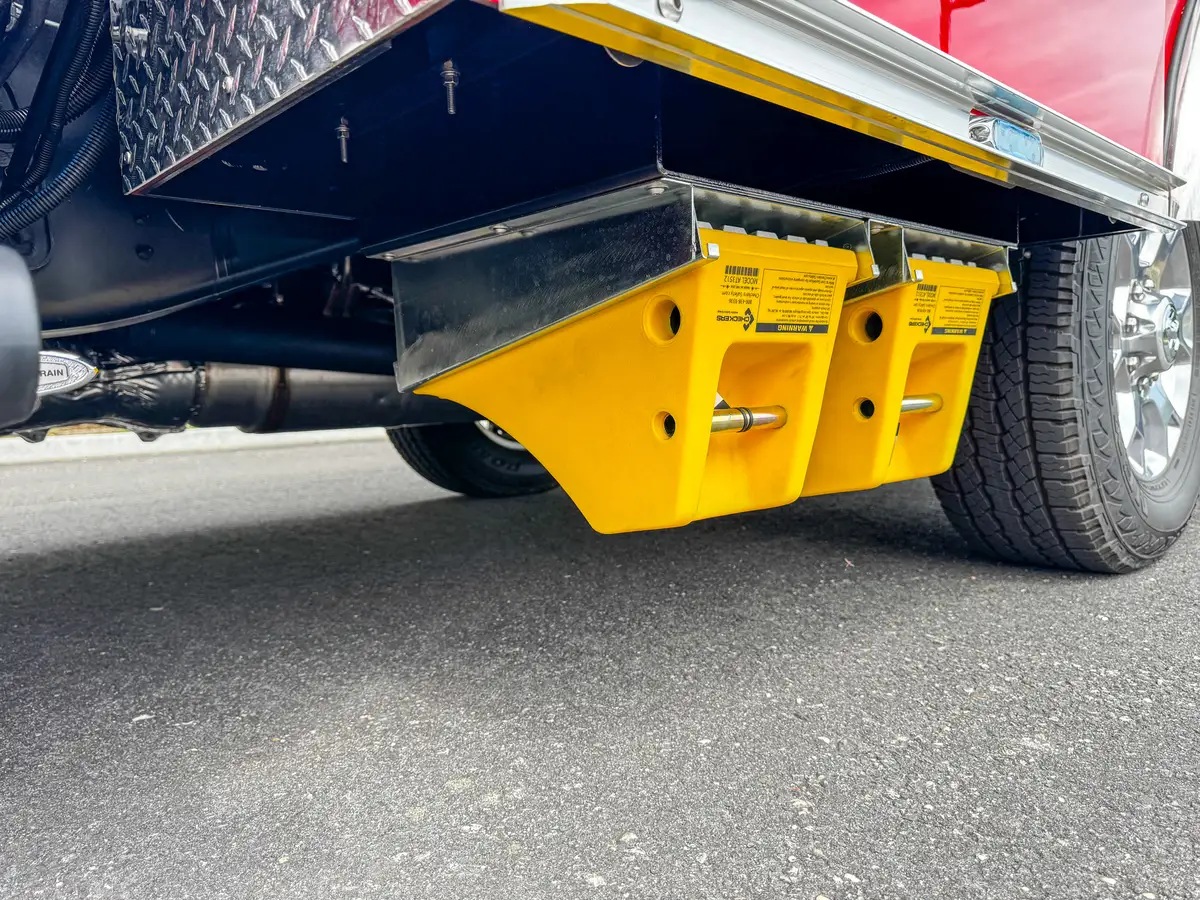 Underside yellow equipment mount beneath body panel.