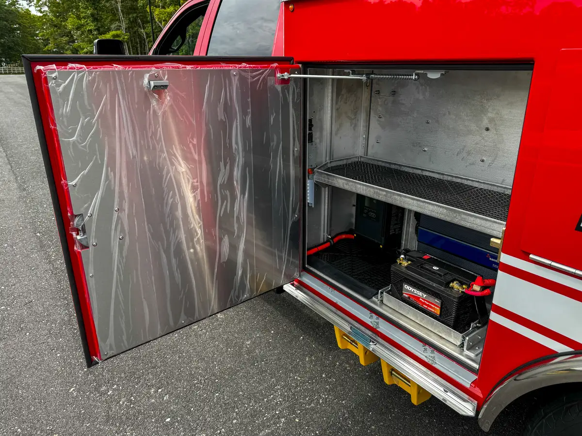 Open side compartment with battery charger and power unit.