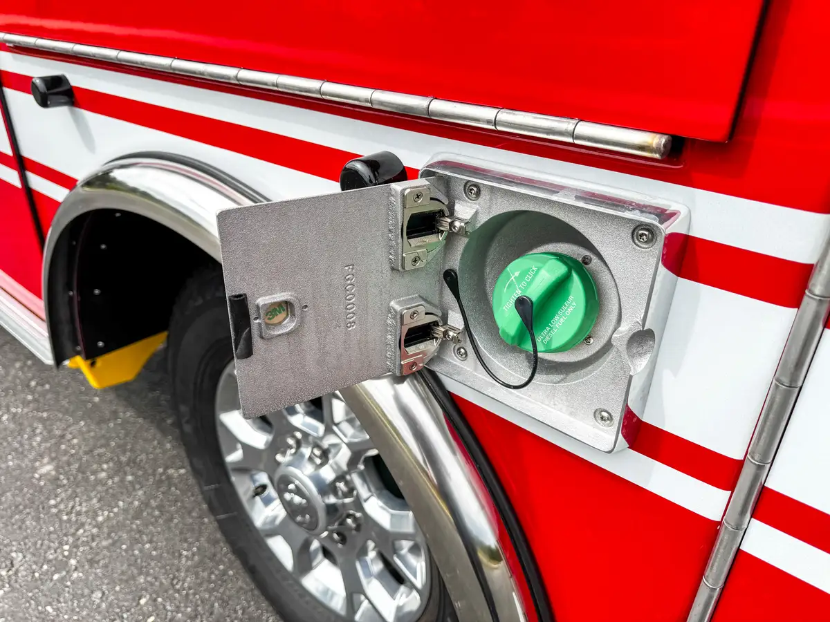Close-up of green-capped fuel inlet on side panel.