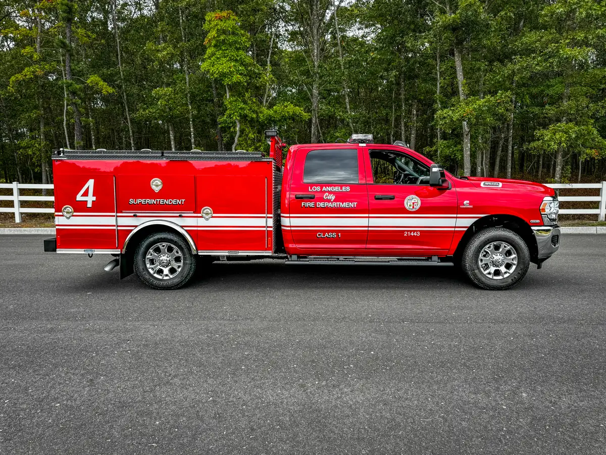 Passenger-side profile of red utility truck with side striping.