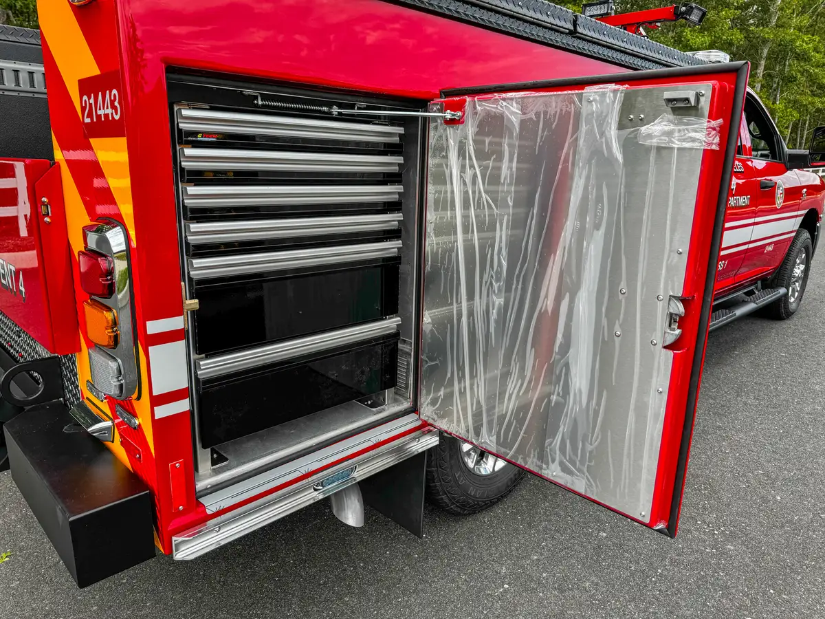 Open rear side compartment with dark shelving units.