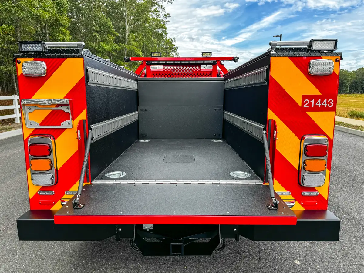 Open rear bed area with tailgate down and side walls.