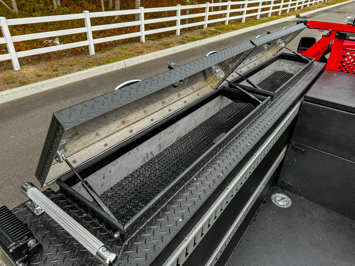 Opposite long bed rail compartment with lid open.