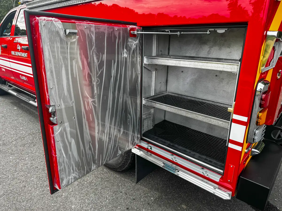 Open rear side compartment with mesh shelves and plastic cover.