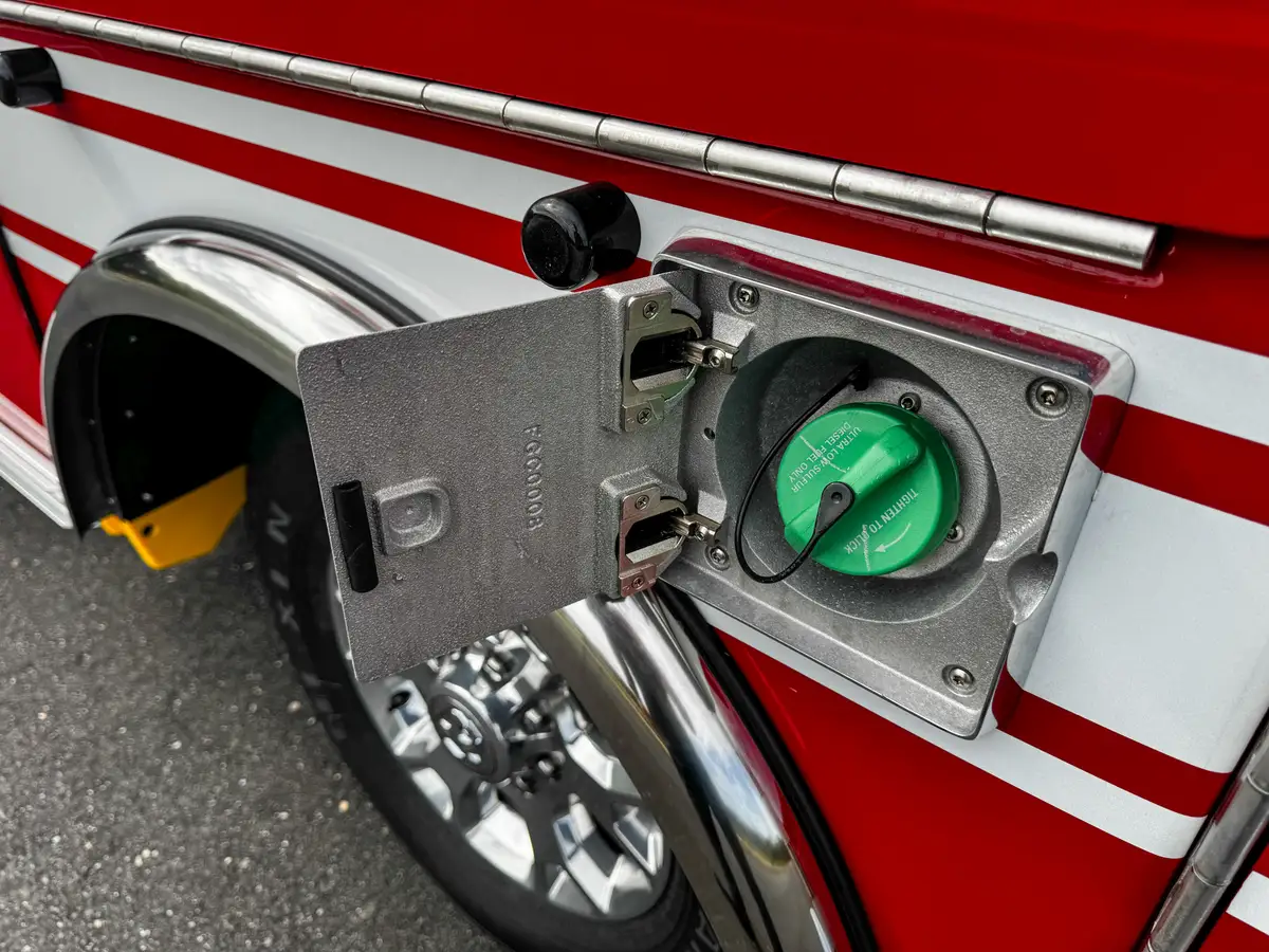 Close-up of side fuel inlet with green cap.
