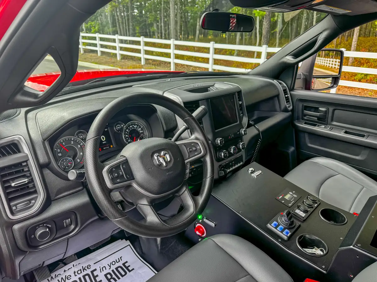 Driver cockpit view with steering wheel and center controls.