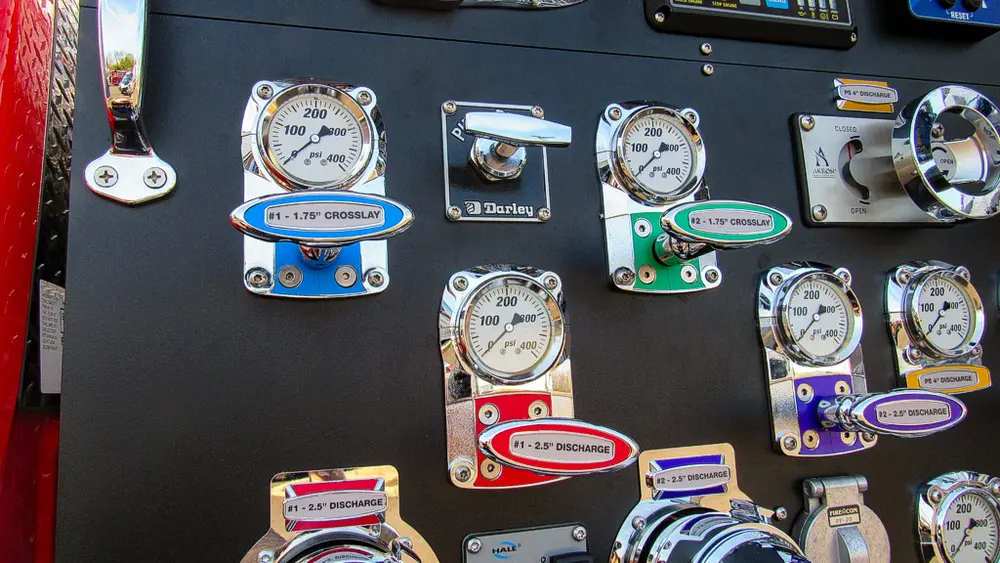 Exterior view of small fire truck showing cab, body compartments, and wheel/tire area.