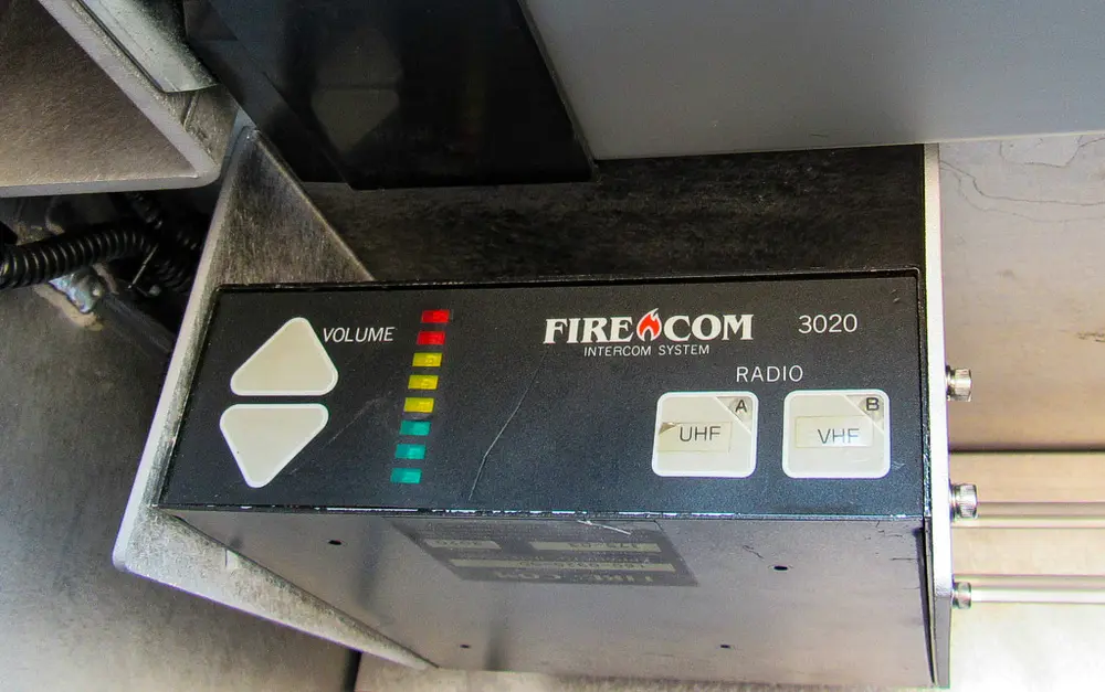 Exterior view of small fire truck showing cab, body compartments, and wheel/tire area.