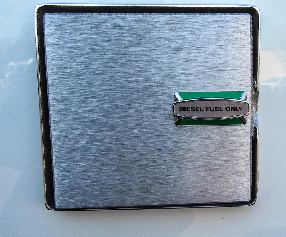 Exterior view of small fire truck showing cab, body compartments, and wheel/tire area.