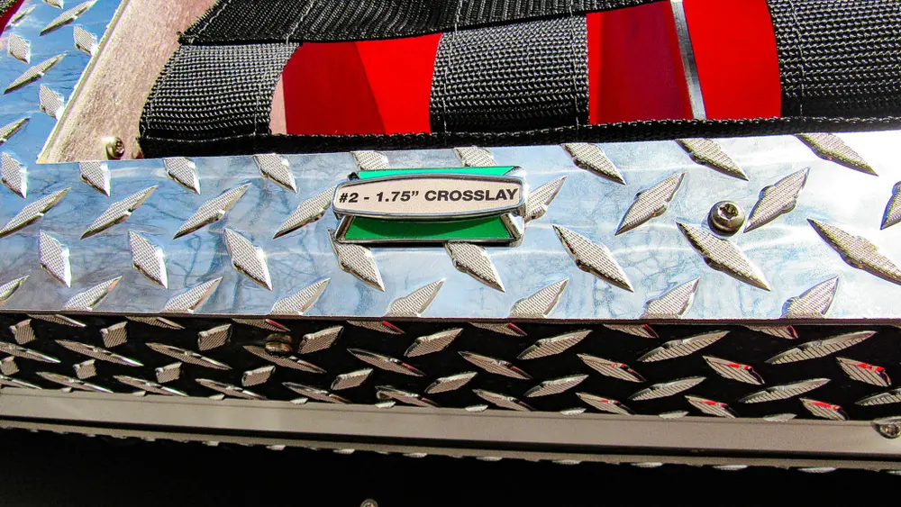 Exterior view of small fire truck showing cab, body compartments, and wheel/tire area.