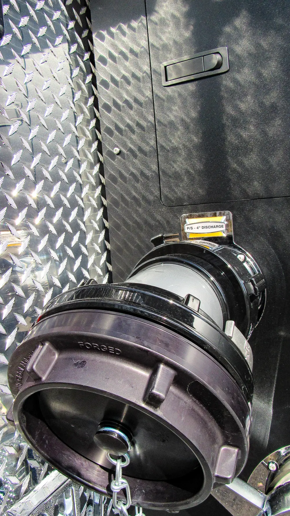 Exterior view of small fire truck showing cab, body compartments, and wheel/tire area.