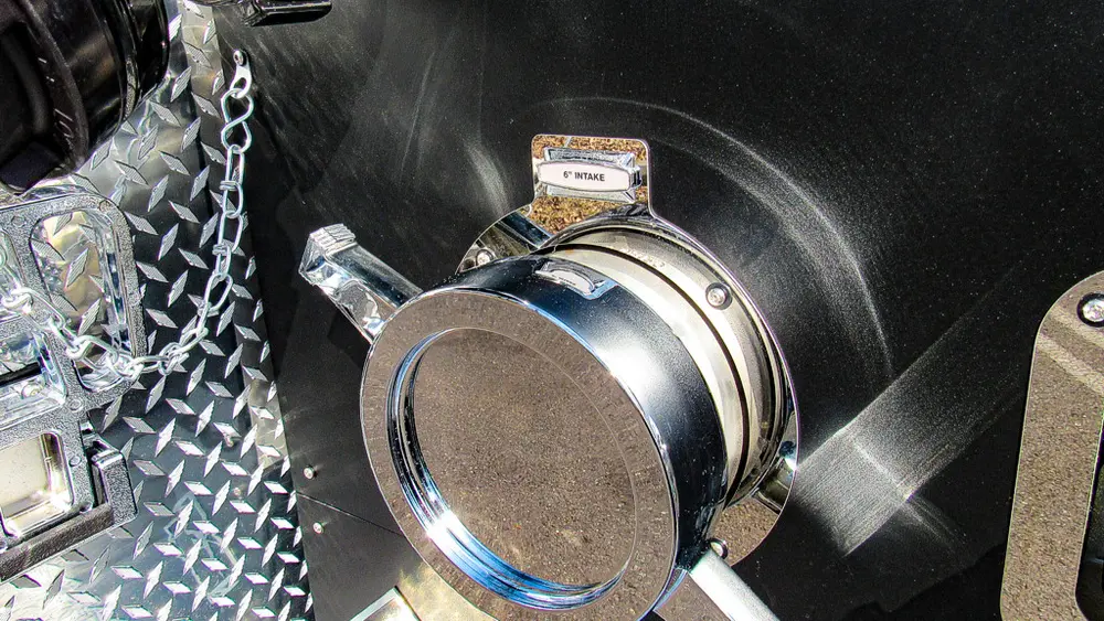 Exterior view of small fire truck showing cab, body compartments, and wheel/tire area.