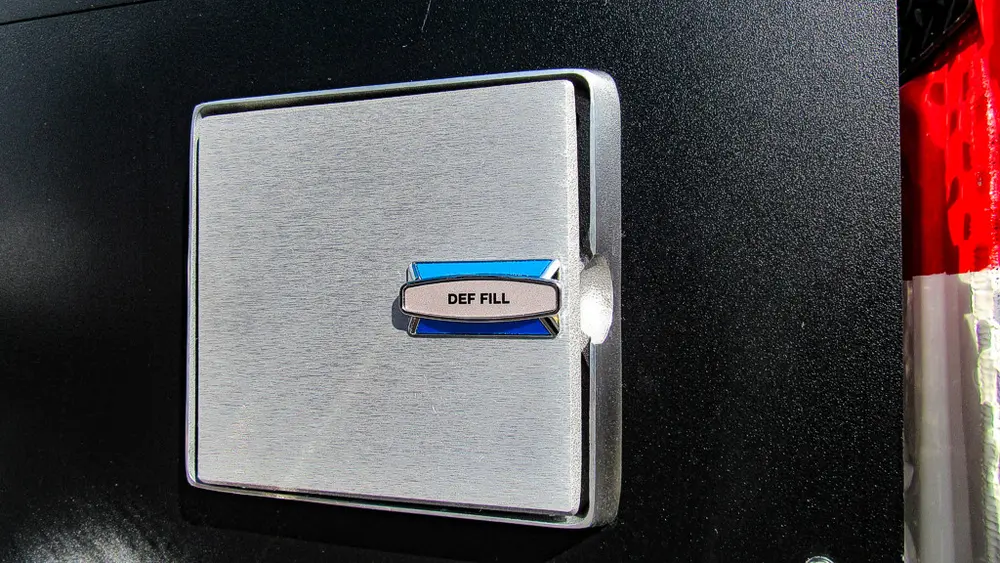 Exterior view of small fire truck showing cab, body compartments, and wheel/tire area.