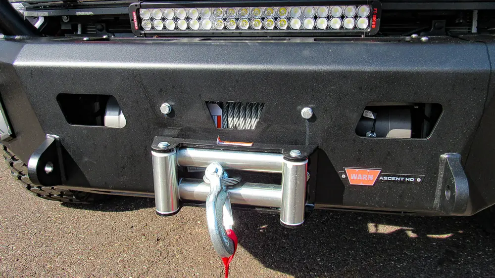 Exterior view of small fire truck showing cab, body compartments, and wheel/tire area.
