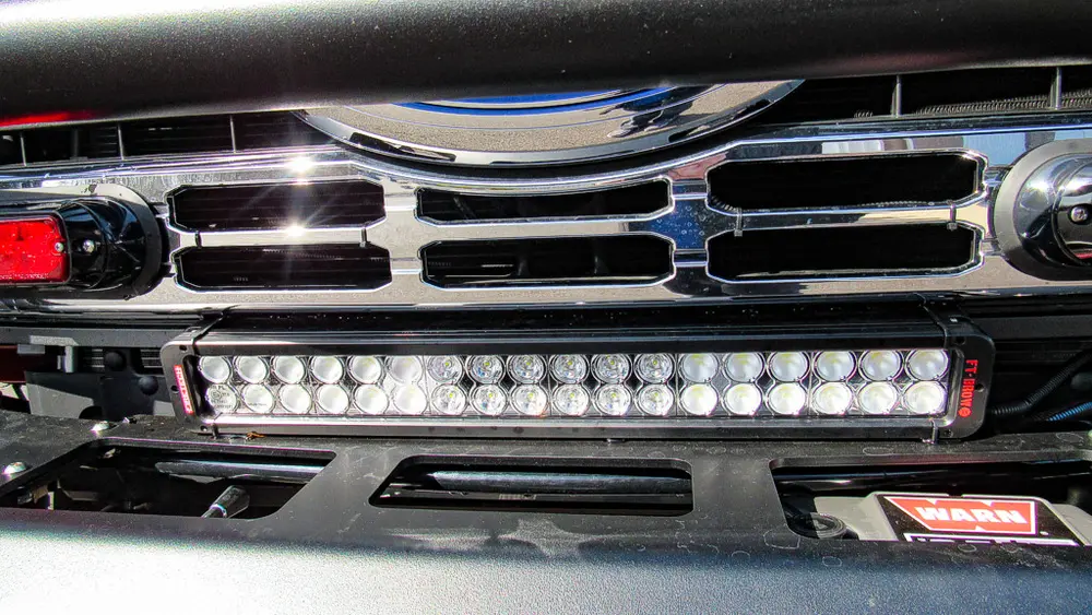 Exterior view of small fire truck showing cab, body compartments, and wheel/tire area.