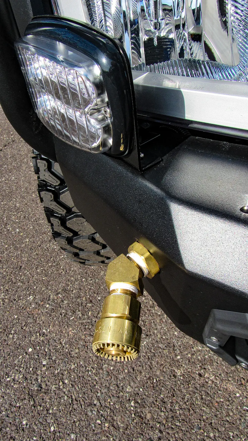 Exterior view of small fire truck showing cab, body compartments, and wheel/tire area.