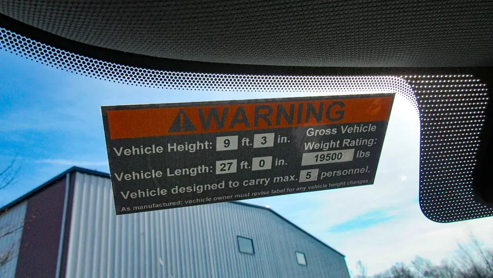 Exterior view of small fire truck showing cab, body compartments, and wheel/tire area.