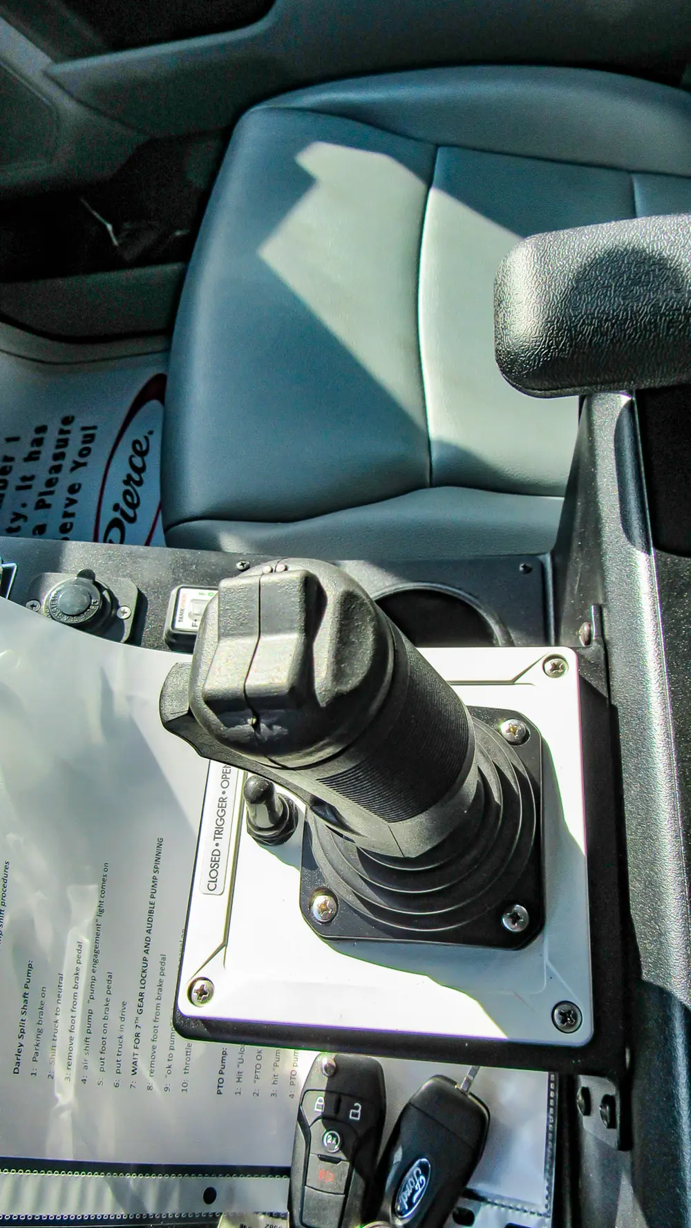Exterior view of small fire truck showing cab, body compartments, and wheel/tire area.