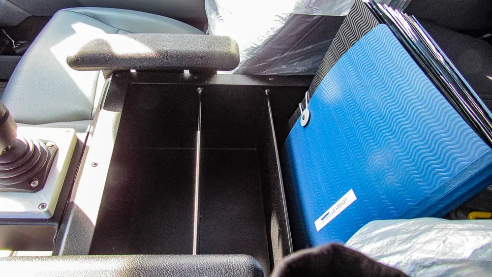 Exterior view of small fire truck showing cab, body compartments, and wheel/tire area.