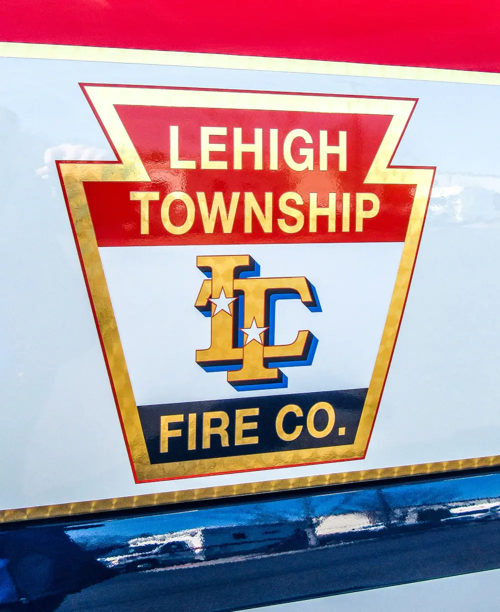 Exterior view of small fire truck showing cab, body compartments, and wheel/tire area.