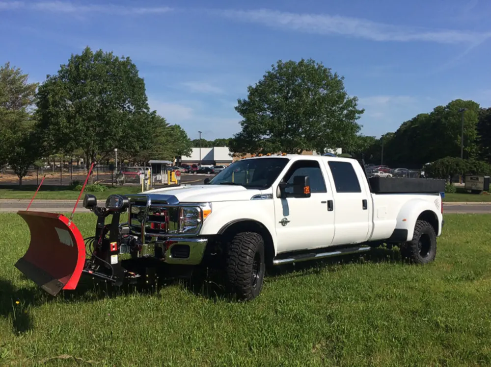Exterior view of small fire truck showing cab, body compartments, and wheel/tire area.