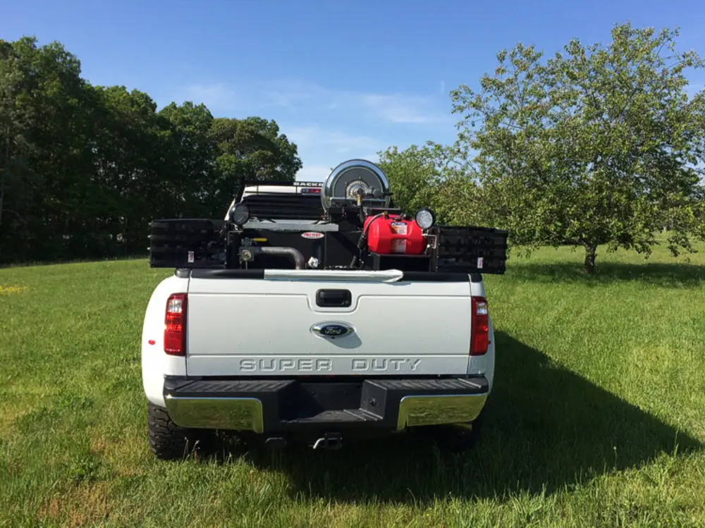 Exterior view of small fire truck showing cab, body compartments, and wheel/tire area.