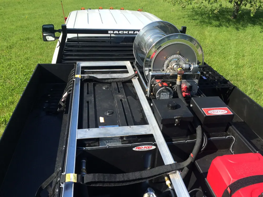 Exterior view of small fire truck showing cab, body compartments, and wheel/tire area.