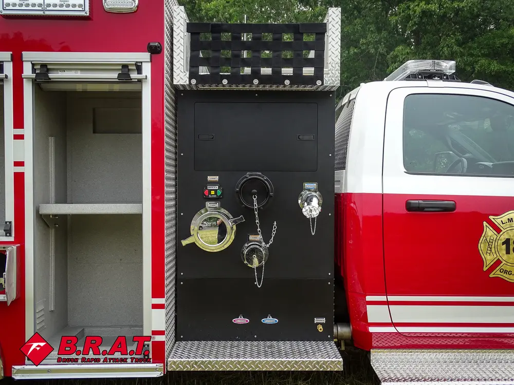 Exterior view of small fire truck showing cab, body compartments, and wheel/tire area.