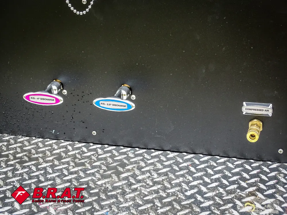 Exterior view of small fire truck showing cab, body compartments, and wheel/tire area.