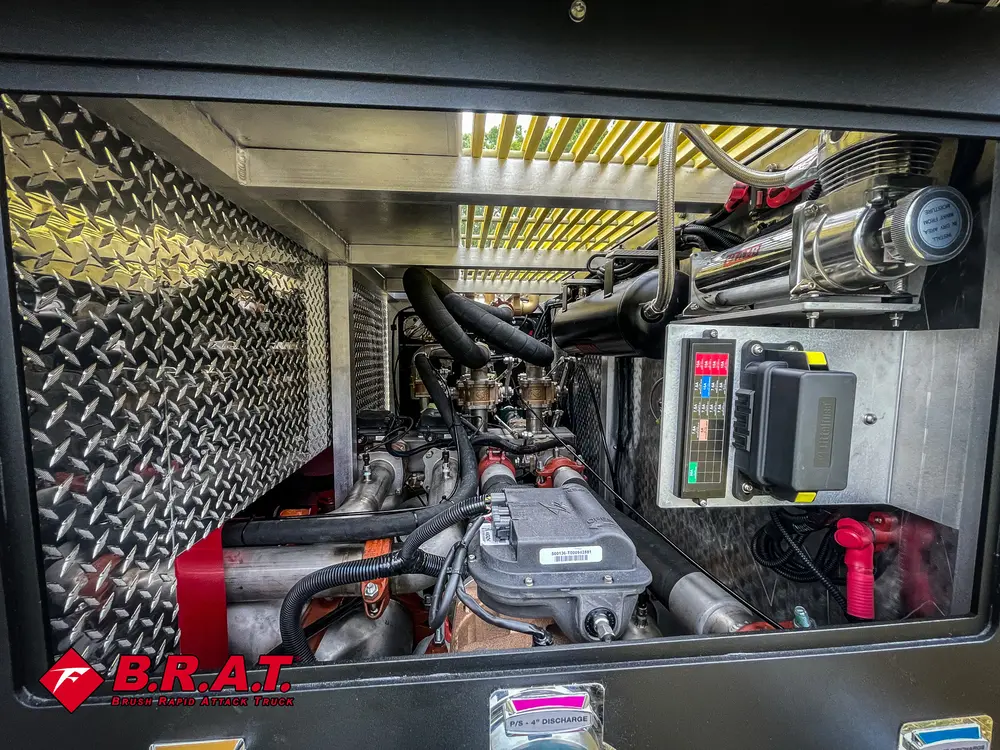 Exterior view of small fire truck showing cab, body compartments, and wheel/tire area.