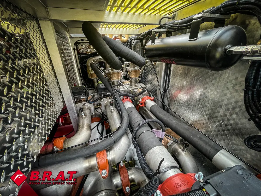 Exterior view of small fire truck showing cab, body compartments, and wheel/tire area.