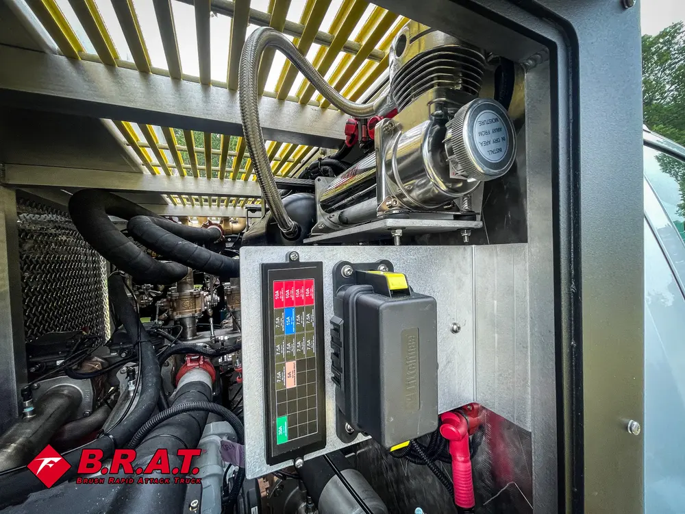 Exterior view of small fire truck showing cab, body compartments, and wheel/tire area.