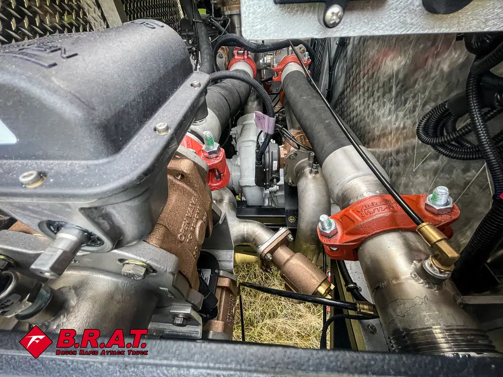 Exterior view of small fire truck showing cab, body compartments, and wheel/tire area.