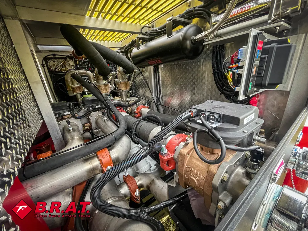 Exterior view of small fire truck showing cab, body compartments, and wheel/tire area.