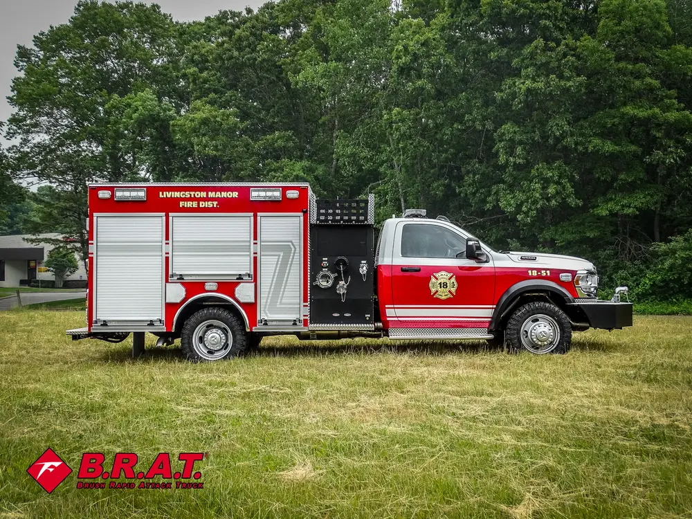 Exterior view of small fire truck showing cab, body compartments, and wheel/tire area.