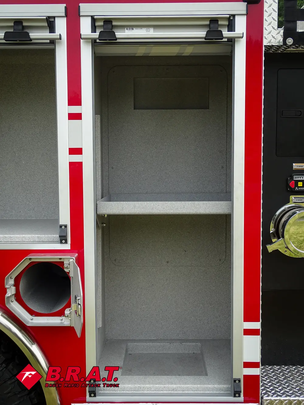 Exterior view of small fire truck showing cab, body compartments, and wheel/tire area.