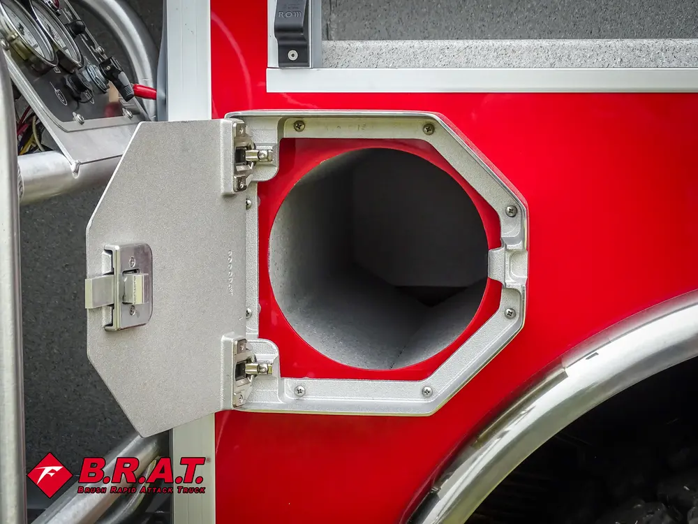 Exterior view of small fire truck showing cab, body compartments, and wheel/tire area.