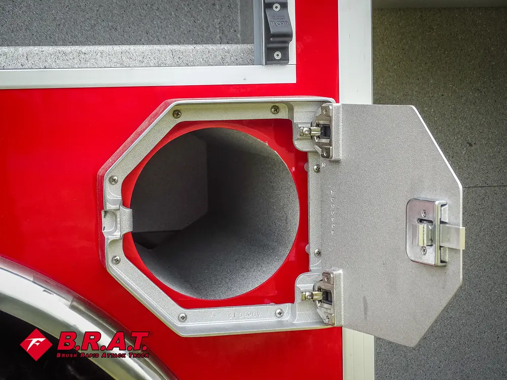 Exterior view of small fire truck showing cab, body compartments, and wheel/tire area.