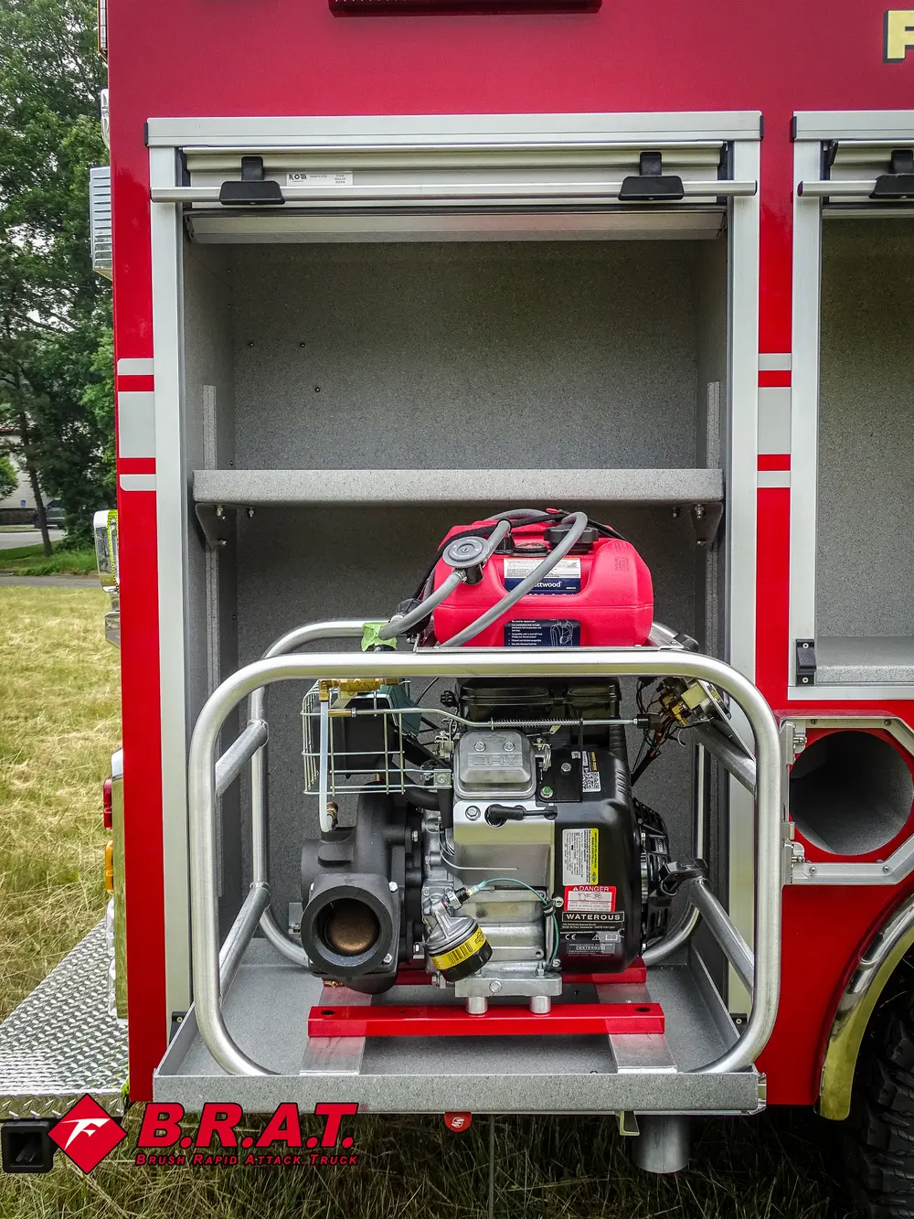 Exterior view of small fire truck showing cab, body compartments, and wheel/tire area.