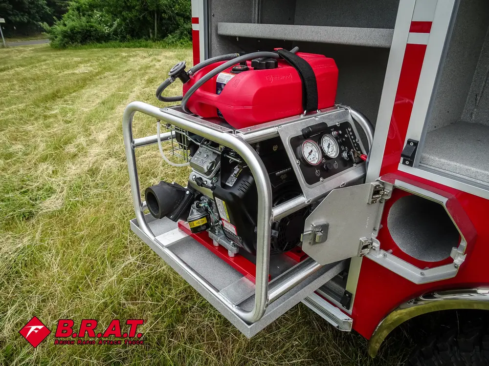 Exterior view of small fire truck showing cab, body compartments, and wheel/tire area.