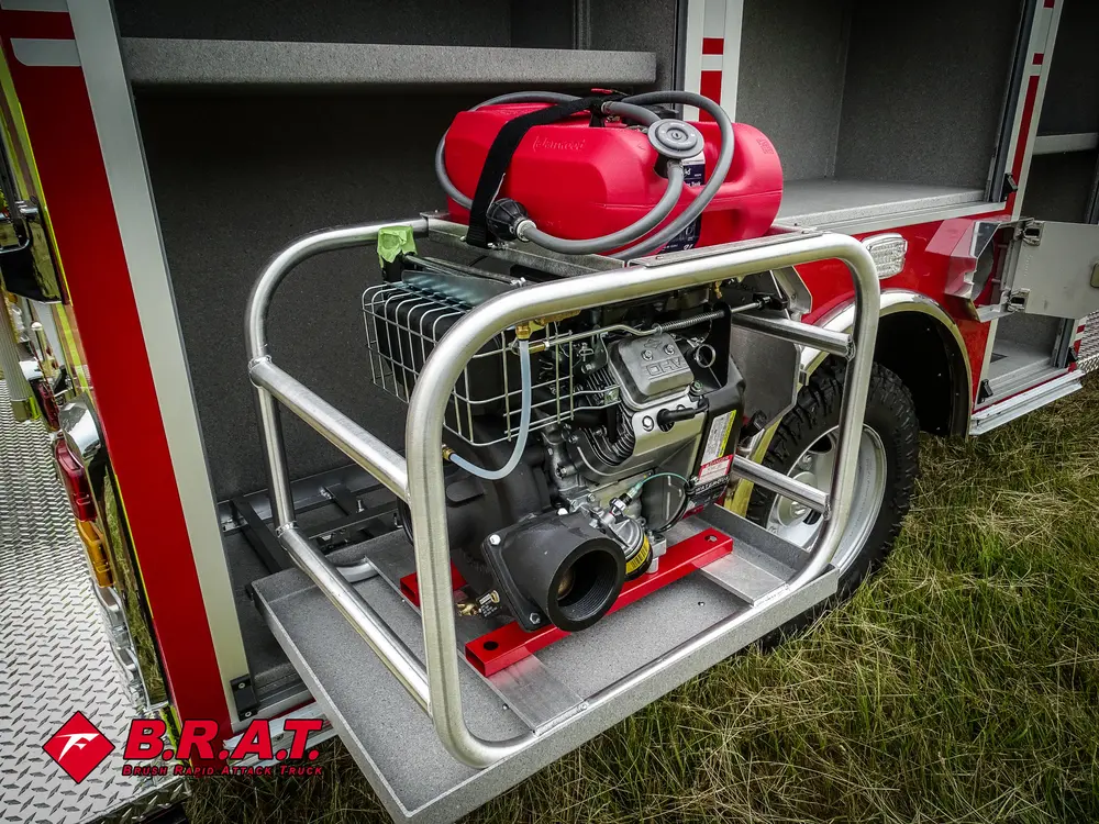 Exterior view of small fire truck showing cab, body compartments, and wheel/tire area.