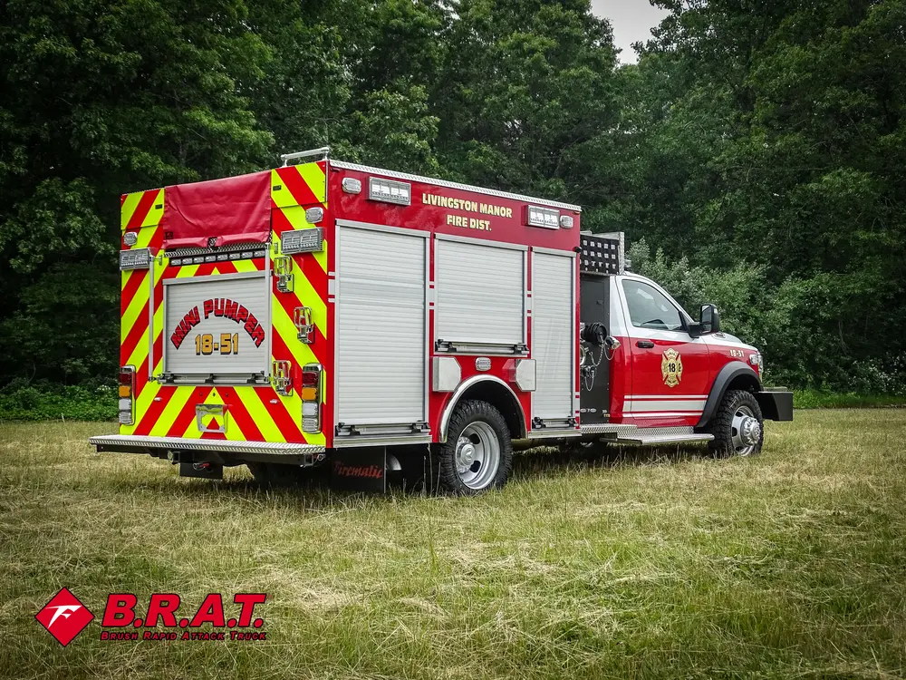 Exterior view of small fire truck showing cab, body compartments, and wheel/tire area.
