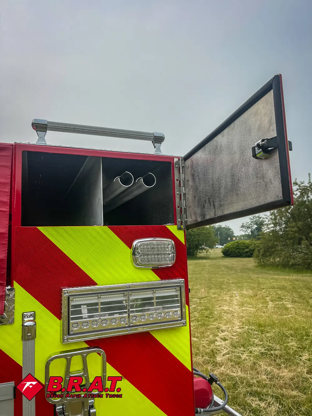 Exterior view of small fire truck showing cab, body compartments, and wheel/tire area.