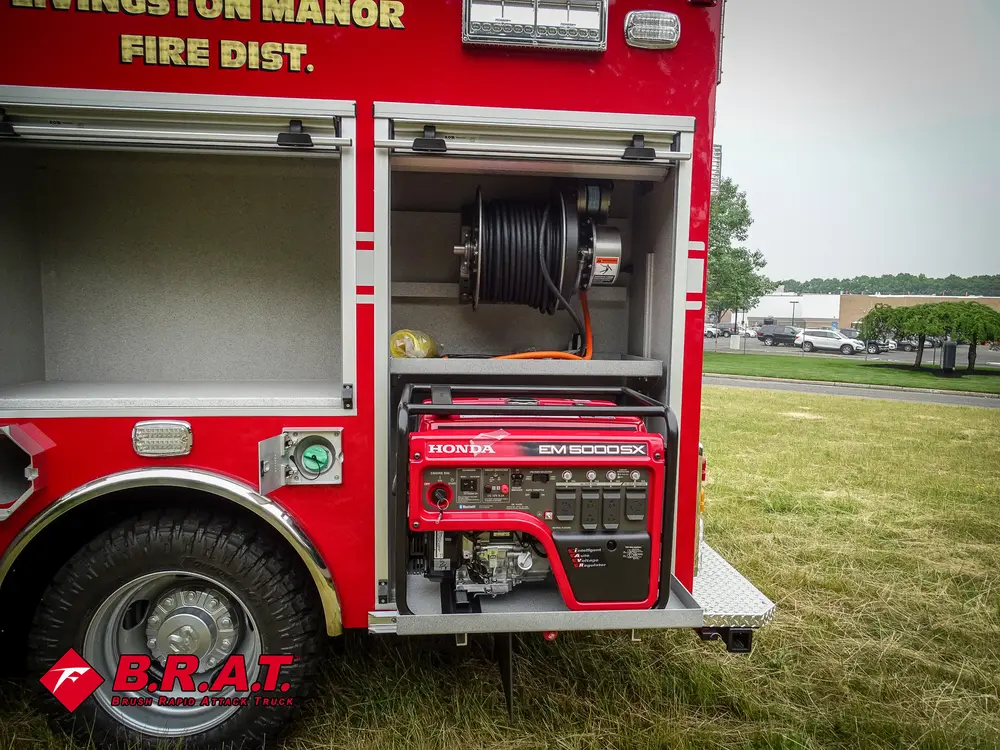 Exterior view of small fire truck showing cab, body compartments, and wheel/tire area.