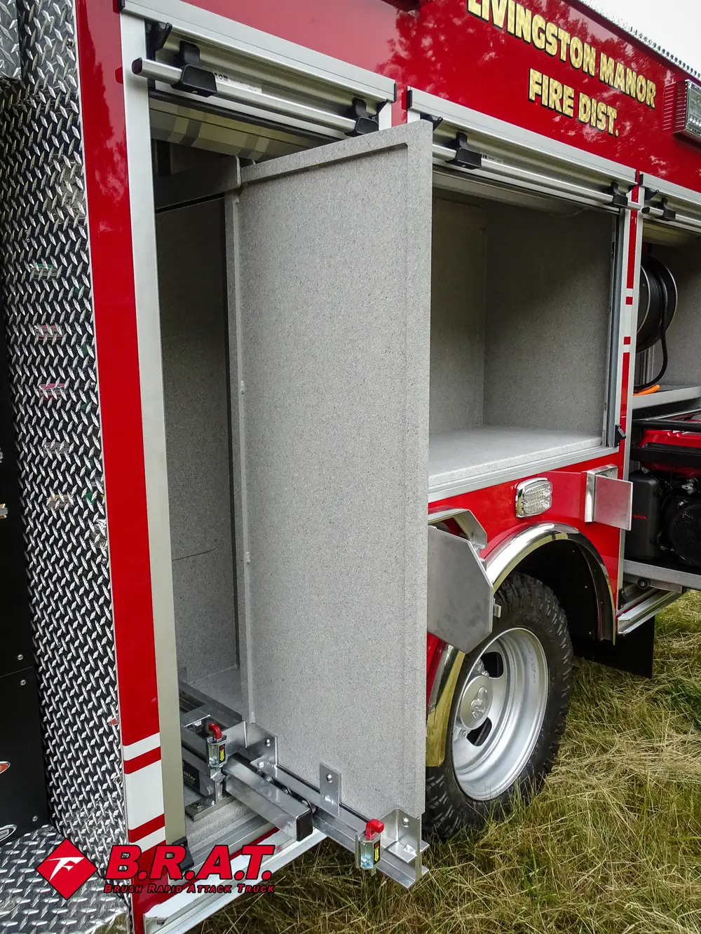 Exterior view of small fire truck showing cab, body compartments, and wheel/tire area.