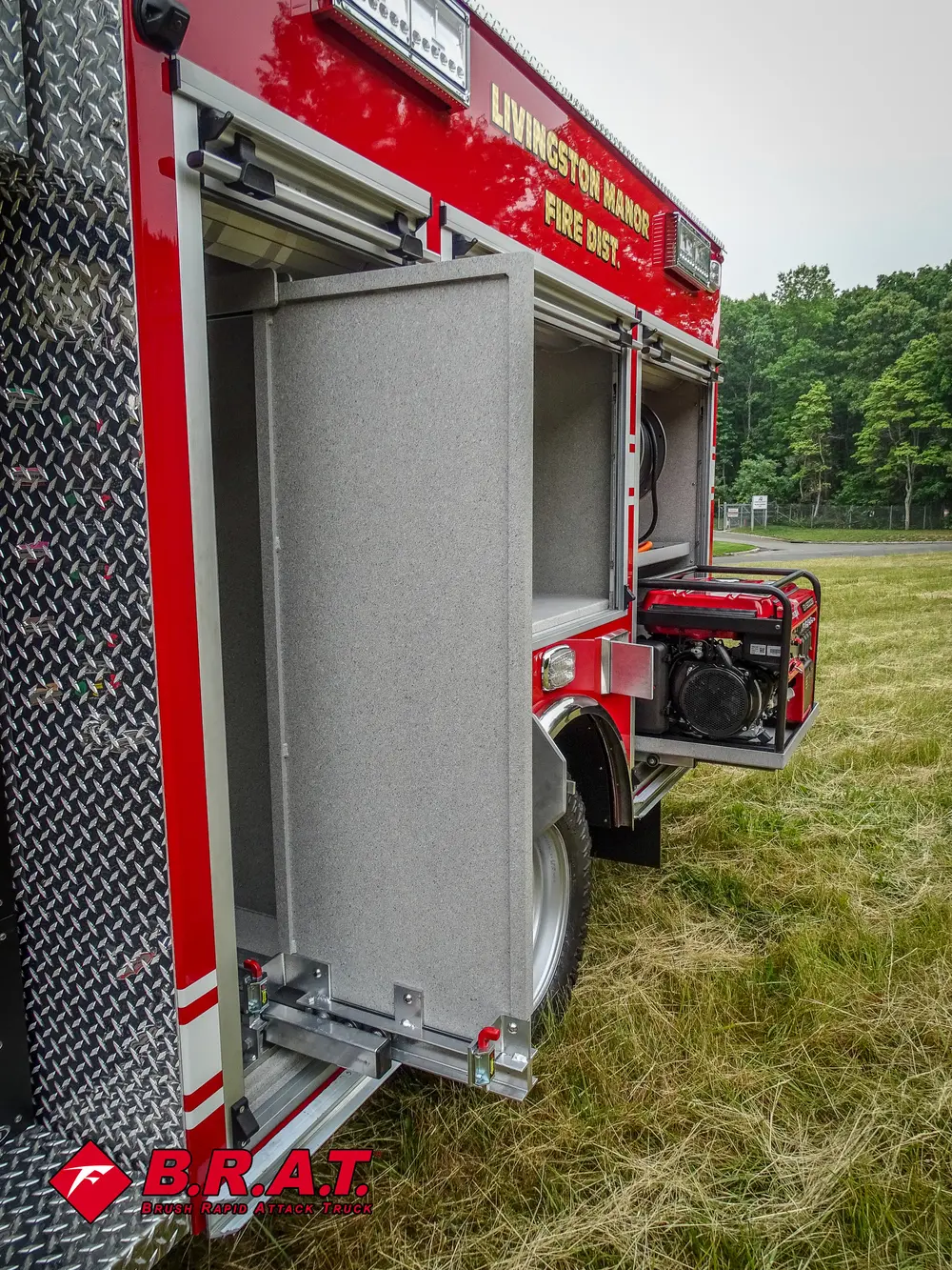 Exterior view of small fire truck showing cab, body compartments, and wheel/tire area.
