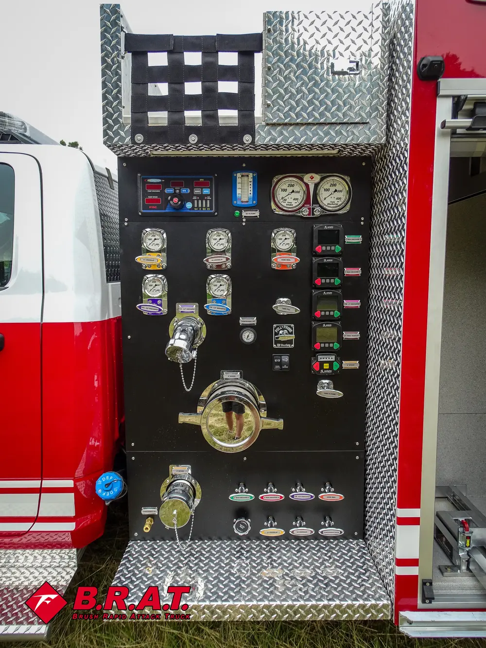 Exterior view of small fire truck showing cab, body compartments, and wheel/tire area.