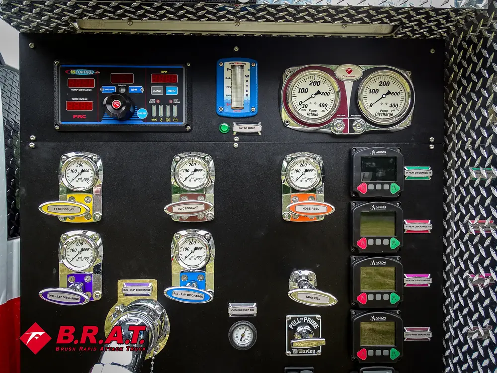 Exterior view of small fire truck showing cab, body compartments, and wheel/tire area.