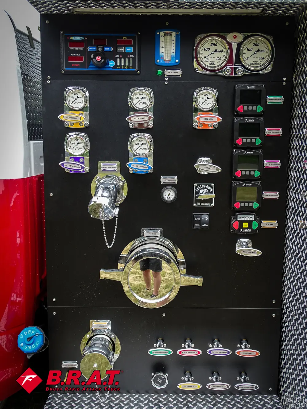 Exterior view of small fire truck showing cab, body compartments, and wheel/tire area.