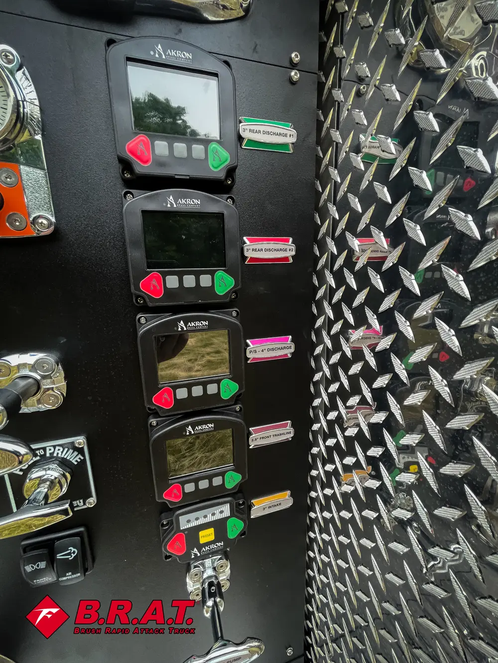 Exterior view of small fire truck showing cab, body compartments, and wheel/tire area.